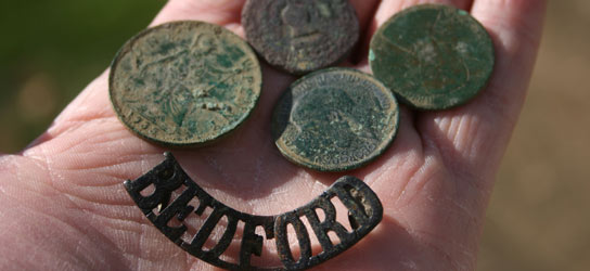 A selection of wonderfully patinated copper coins dating 1750 to 1930 and a shoulder badge of the Bedford Regiment found with the CTX 3030