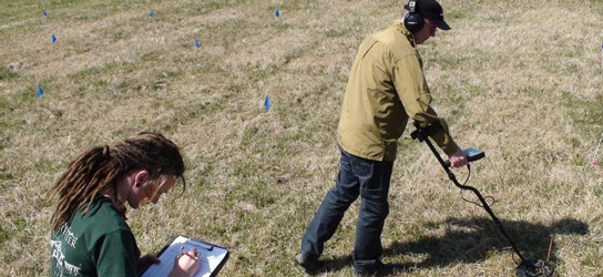 Members of Montpelier's Archaeology Department carefully track and plot every colored stake in the ground as metal detectorists learn how to conduct Metal Detector Surveys